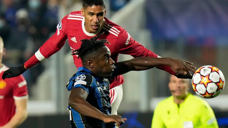 Atalanta's Duvan Zapata, foreground, vies for the ball with Manchester United's Raphael Varane 