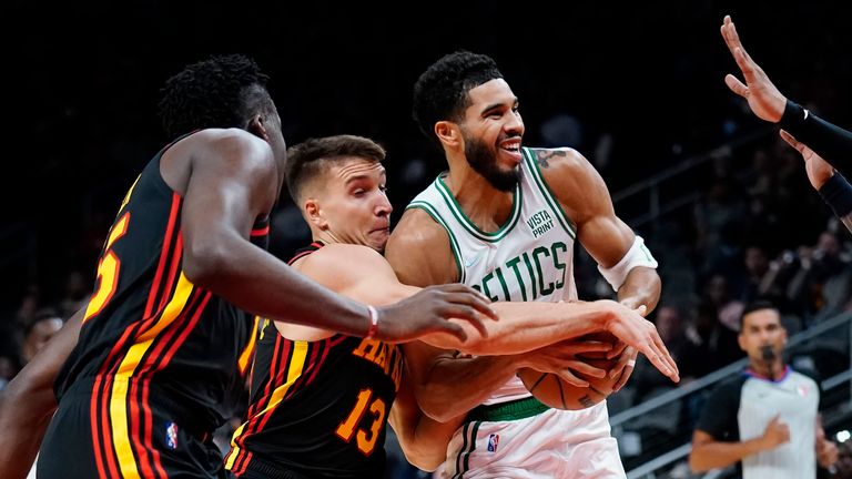 Boston Celtics forward Jayson Tatum (0) is defended by Atlanta Hawks guard Bogdan Bogdanovic (13) as he drives to the basket in the first half of an NBA basketball game Wednesday, Nov. 17, 2021, in Atlanta.