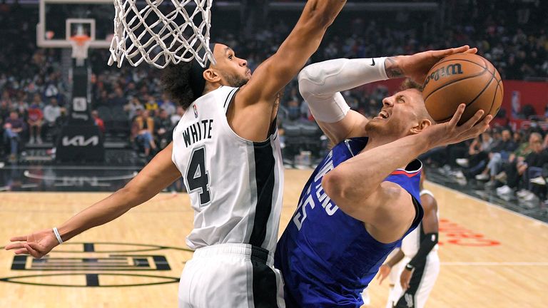 Los Angeles Clippers center Isaiah Hartenstein, right, shoots as San Antonio Spurs guard Derrick White defends during the first half of an NBA basketball game Tuesday, Nov. 16, 2021, in Los Angeles. 
