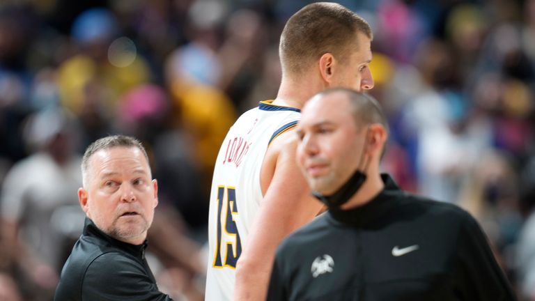 Denver Nuggets head coach Michael Malone, left, guides center Nikola Jokic to the bench after he was involved in an altercation with Miami Heat forward Markieff Morris
