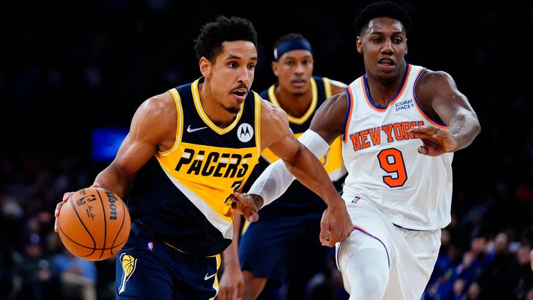 Indiana Pacers '  Malcolm Brogdon (7) passe devant les Knicks de New York’  RJ Barrett (9) lors de la première mi-temps d'un match de basket de la NBA, lundi 15 novembre 2021, à New York.