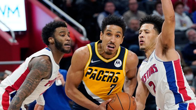 Indiana Pacers guard Malcolm Brogdon (7) drives as Detroit Pistons forward Saddiq Bey, left, and guard Cade Cunningham (2) defend during the second half of an NBA basketball game, Wednesday, Nov. 17, 2021, in Detroit. 