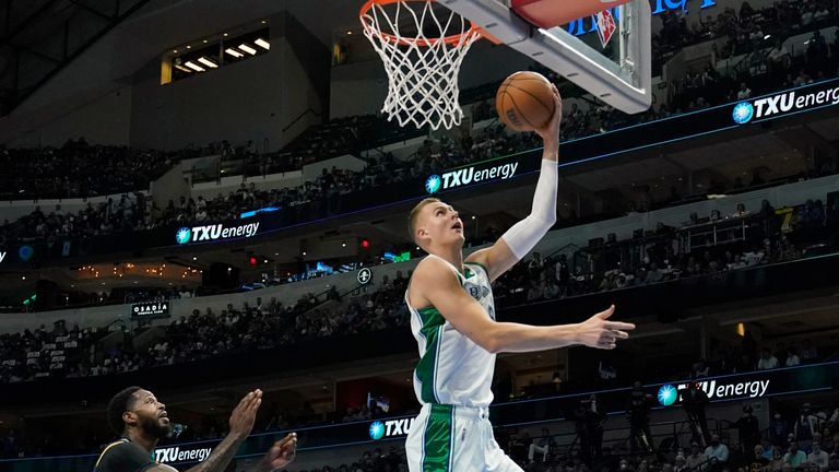 Dallas Mavericks center Kristaps Porzingis (6) goes up for a shot after getting past Denver Nuggets guard Bones Hyland (3) and JaMychal Green (0) in the first half of an NBA basketball game in Dallas, Monday, Nov. 15, 2021.