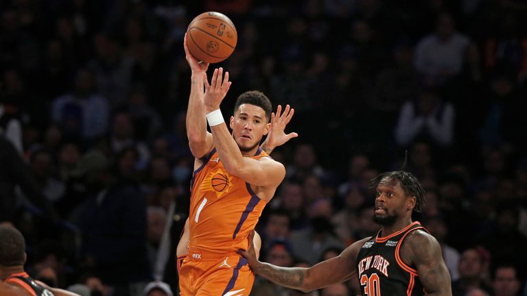 Phoenix Suns&#39; Devin Booker (1) looks to pass over New York Knicks&#39; Julius Randle (30) during the first half of an NBA basketball game Friday, Nov. 26, 2021, in New York. AP Photo/John Munson)


