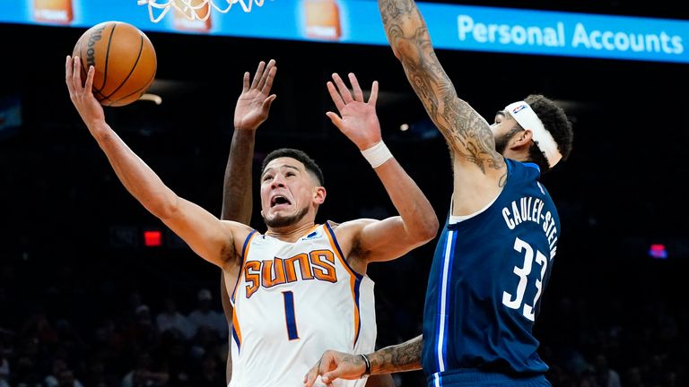 Phoenix Suns guard Devin Booker (1) shoots past Dallas Mavericks center Willie Cauley-Stein (33) during the second half of an NBA basketball game, Wednesday, Nov. 17, 2021, in Phoenix. (