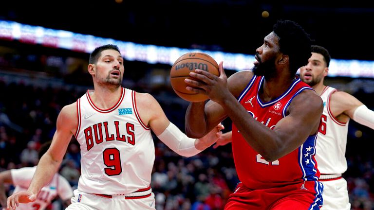 Philadelphia 76ers' Joel Embiid looks to shoot as Chicago Bulls' Nikola Vucevic (9) and Zach LaVine defend during the first half of an NBA basketball game Saturday, Nov. 6, 2021, in Chicago. (AP Photo/Charles Rex Arbogast)