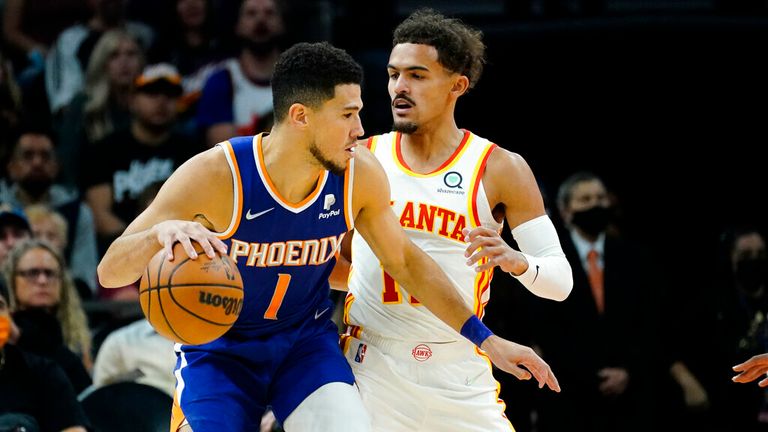Phoenix Suns guard Devin Booker (1) backs down Atlanta Hawks guard Trae Young during the first half of an NBA basketball game, Saturday, Nov. 6, 2021, in Phoenix. (AP Photo/Matt York)