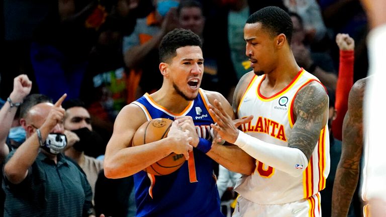 Phoenix Suns guard Devin Booker (1) and Atlanta Hawks forward John Collins get tangled up during the second half of an NBA basketball game, Saturday, Nov. 6, 2021, in Phoenix. The Suns won 121-117. (AP Photo/Matt York)