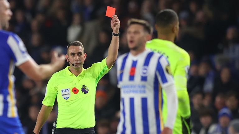 Referee David Coote gives a red card to Brighton keeper Robert Sanchez