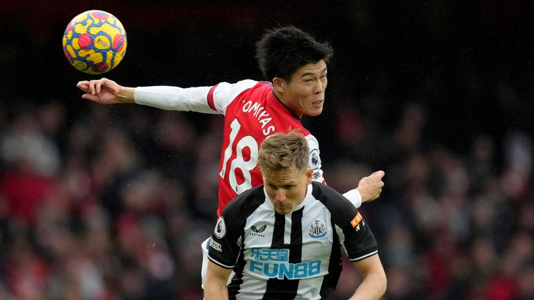 Takehiro Tomiyasu jumps for the ball with Newcastle's Matt Ritchie (AP)