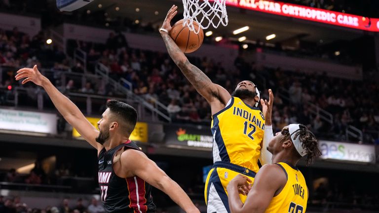 Indiana Pacers forward Oshae Brissett (12) pulls in a rebound next to Miami Heat center Omer Yurtseven (77) during the first half of an NBA basketball game in Indianapolis, Friday, Dec. 3, 2021. (AP Photo/AJ Mast)


