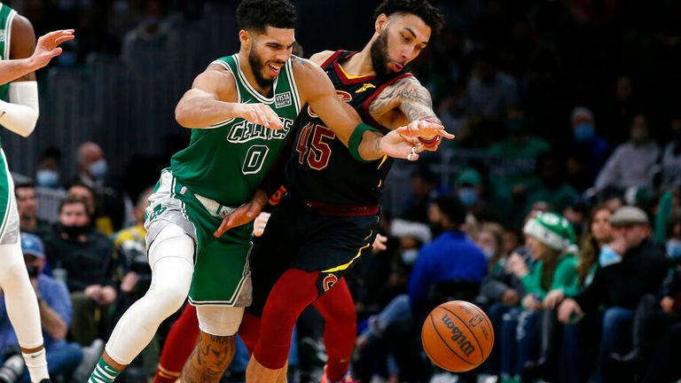 Boston Celtics&#39; Jayson Tatum (0) and Cleveland Cavaliers&#39; Denzel Valentine go for a loose ball during the second half of an NBA basketball game Wednesday, Dec. 22, 2021, in Boston. (AP Photo/Winslow Townson)