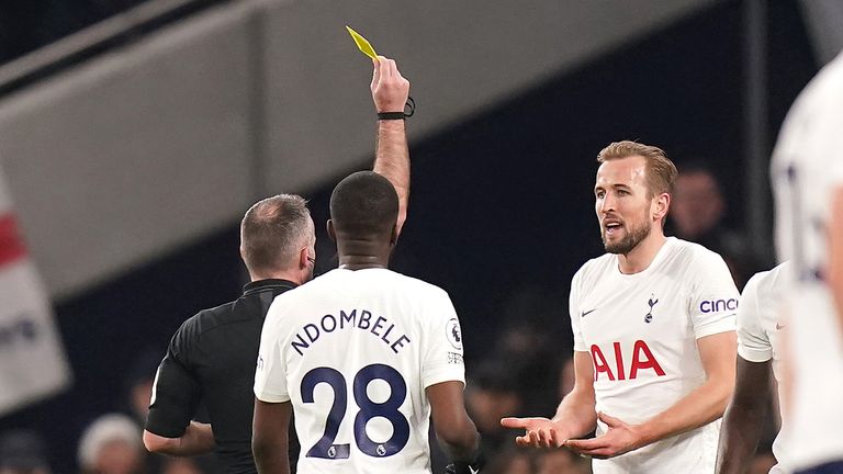 Referee Paul Tierney shows a yellow card to Tottenham Hotspur&#39;s Harry Kane