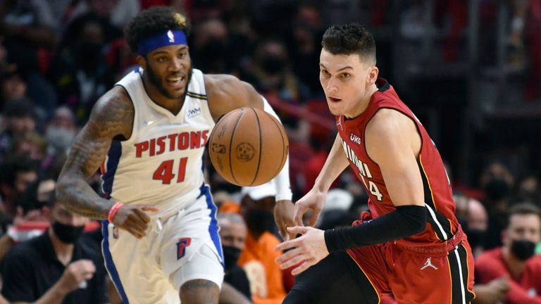 Miami Heat guard Tyler Herro (14) picks up a loose ball as Detroit Pistons forward Saddiq Bey (41) follows on the play during the second half of an NBA basketball game, Thursday, Dec. 23, 2021, in Miami. 