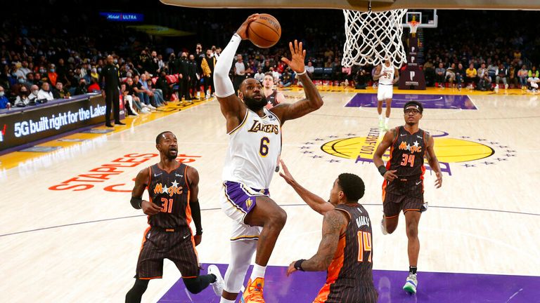 Los Angeles Lakers forward LeBron James (6) hits the basket against Orlando Magic guard Gary Harris (14) during the second half of an NBA basketball game in Los Angeles on Sunday, December 12, 2021. The Lakers won 106 -94.  (Photo AP / Ringo HW Chiu)
