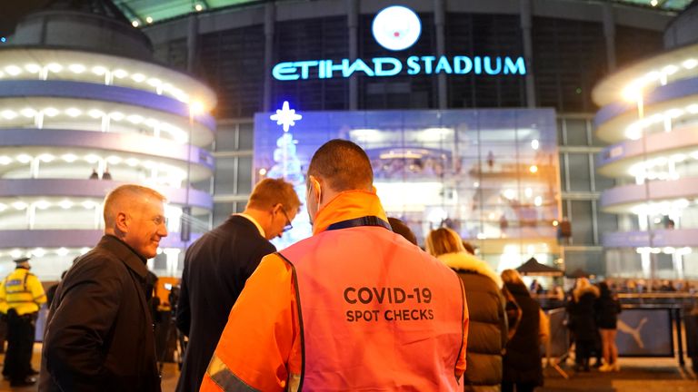 Arriving fans receive Covid-19 spot checks ahead of a Premier League match at Manchester City