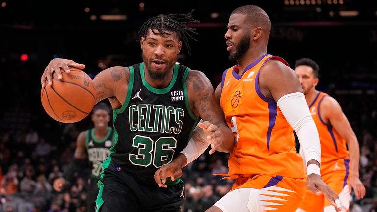 Boston Celtics guard Marcus Smart handles  the ball whilst Phoenix Suns guard Chris Paul defends