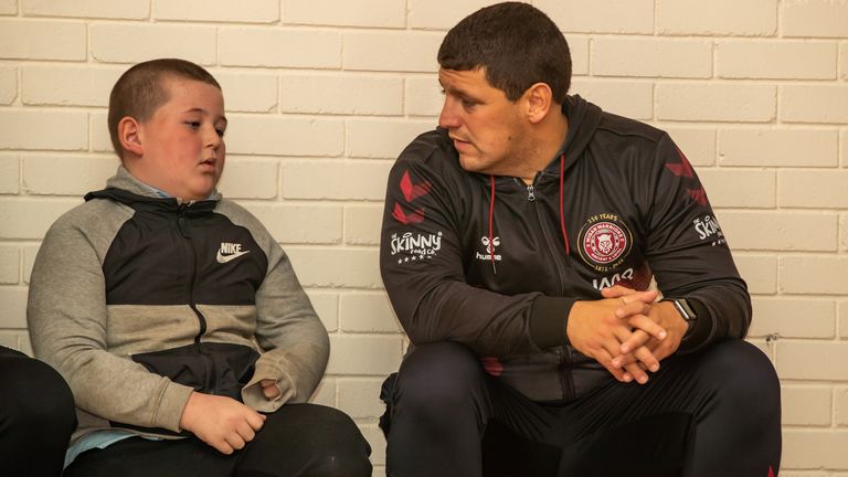 Wigan Warriors head coach Matt Peet speaks to a pupil during the Warriors Unite session at St Benedict's Primary School