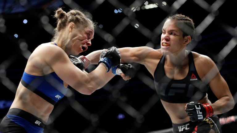 Amanda Nunes (right) punches Ronda Rousey during their bout for the UFC women's bantamweight championship at UFC 207 in 2016