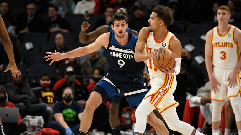 Atlanta Hawks guard Trae Young, front right, looks to pass around Minnesota Timberwolves guard Leandro Bolmaro (9) during the first half of an NBA basketball game Monday, Dec. 6, 2021, in Minneapolis. (AP Photo/Craig Lassig)


