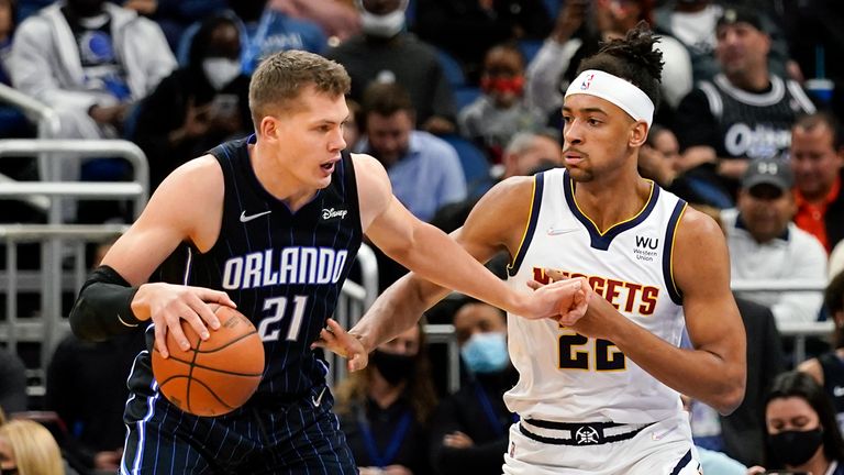 Orlando Magic center Moritz Wagner (21) makes a move to the basket against Denver Nuggets forward Zeke Nnaji, right, during the first half of an NBA basketball game, Wednesday, Dec. 1, 2021, in Orlando, Fla. (AP Photo/John Raoux)



