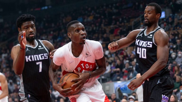 Toronto Raptors forward Chris Boucher, center, fights for a rebound with Sacramento Kings&#39; Harrison Barnes, right, and Chimezie Metu during first-half NBA basketball game action in Toronto, Monday, Dec. 13, 2021. (Chris Young/The Canadian Press via AP)


