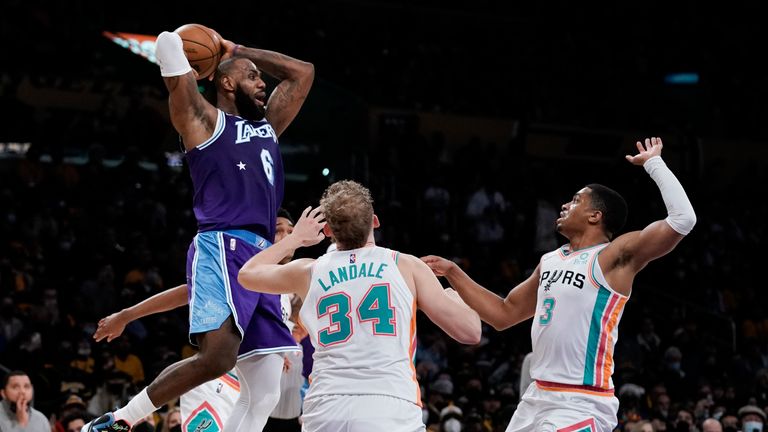 Los Angeles Lakers&#39; LeBron James, top left, looks to pass under pressure by San Antonio Spurs&#39; Jock Landale, center, and Keldon Johnson during first half of an NBA basketball game Thursday, Dec. 23, 2021, in Los Angeles.
