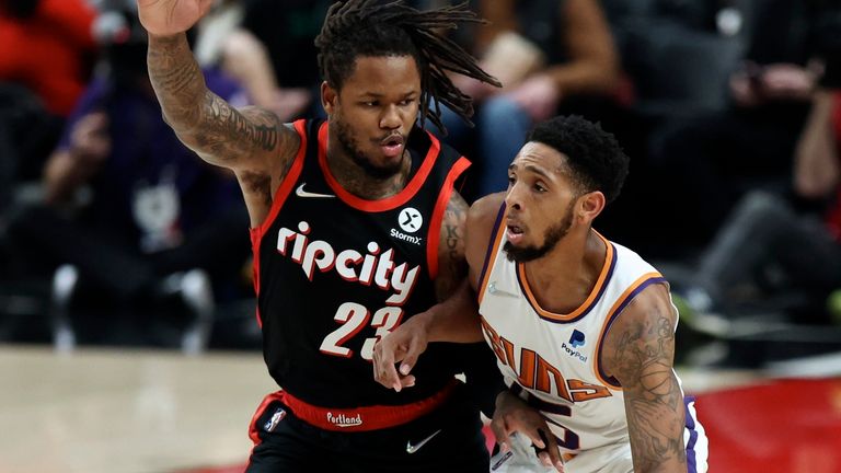 Phoenix Suns guard Cameron Payne, right, drives the ball down court against Portland Trail Blazers guard Ben McLemore, left, during the first half of an NBA basketball game in Portland, Ore., Tuesday, Dec. 14, 2021. 