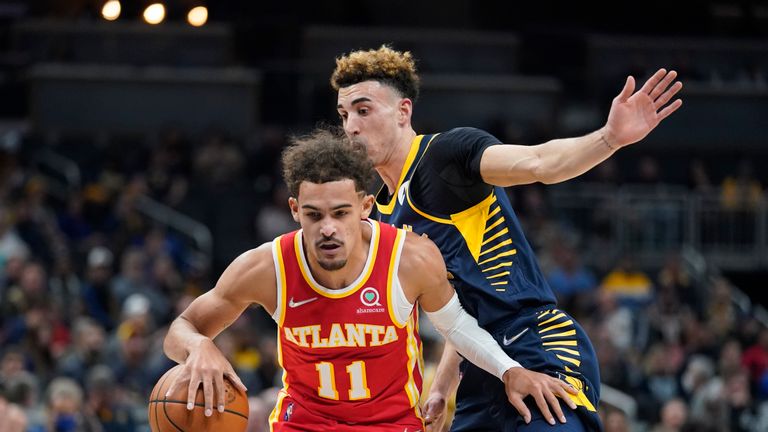 Atlanta Hawks&#39; Trae Young (11) is defended by Indiana Pacers&#39; Chris Duarte during the first half of an NBA basketball game Wednesday, Dec. 1, 2021, in Indianapolis. (AP Photo/Darron Cummings)


