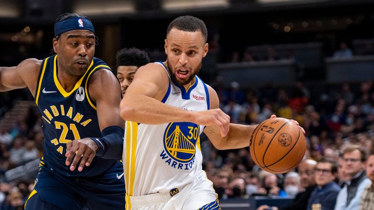 Golden State Warriors guard Stephen Curry (30) drives the ball past the defense of Indiana Pacers guard Kelan Martin (21) during the first half of an NBA basketball game in Indianapolis, Monday, Dec. 13, 2021. (AP Photo/Doug McSchooler)


