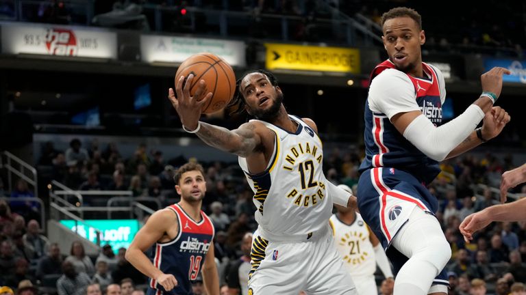 Indiana Pacers forward Oshae Brissett (12) pulls in a rebound behind Washington Wizards center Daniel Gafford (21) during the second half of an NBA basketball game in Indianapolis, Monday, Dec. 6, 2021. (AP Photo/AJ Mast)


