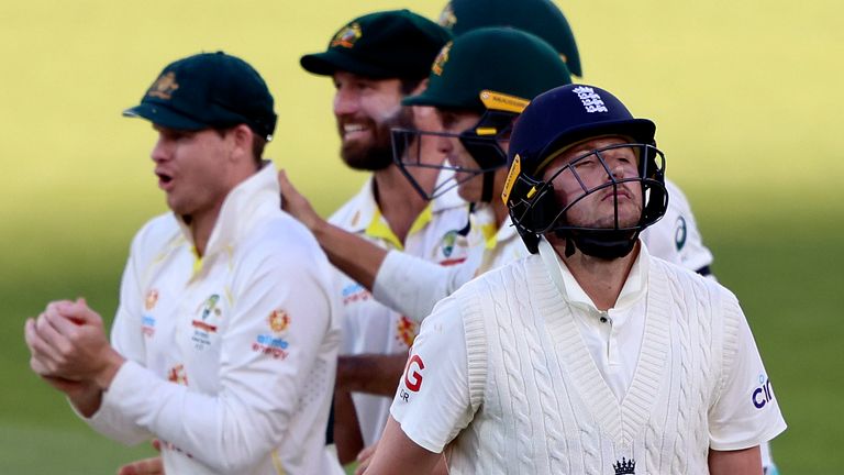 England's Ollie Robinson, front, walks off after he was caught out by Australia's Steve Smith, left, during the fifth day of their Ashes cricket test match in Adelaide, Australia, Monday, Dec. 20, 2021. (AP Photo/James Elsby)
