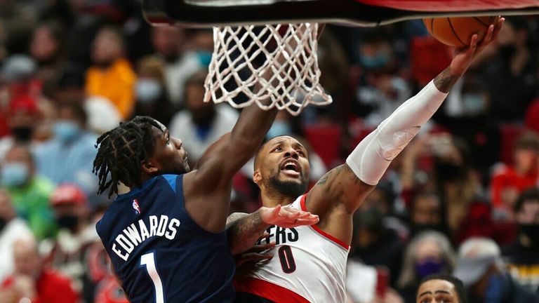 Portland Trail Blazers guard Damian Lillard, right, shoots as Minnesota Timberwolves forward Anthony Edwards, left, defends during the second half of an NBA basketball game in Portland, Ore., Sunday, Dec. 12, 2021. Minnesota defeated Portland 116-111. (AP Photo/Steve Dipaola)