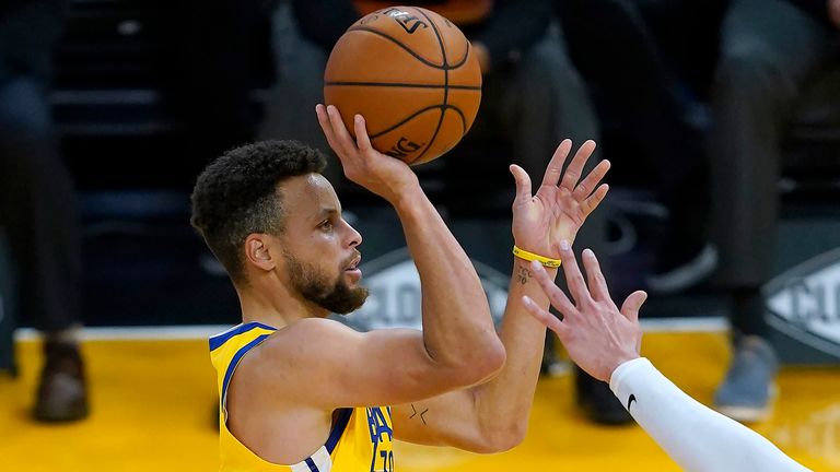 Golden State Warriors guard Stephen Curry takes a three-point shot over Portland Trail Blazers
