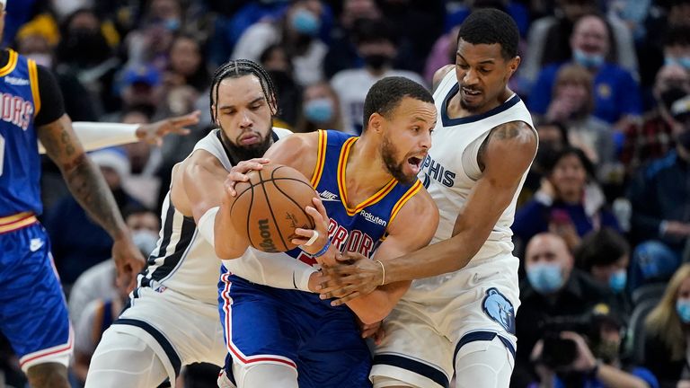 Golden State Warriors guard Stephen Curry, middle, is defended by Memphis Grizzlies forward Dillon Brooks, middle left, and guard De&#39;Anthony Melton during the second half of an NBA basketball game in San Francisco, Thursday, Dec. 23, 2021.