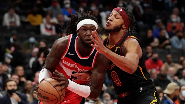 Washington Wizards' Montrezl Harrell, left, is fouled by Cleveland Cavaliers' Lamar Stevens (8) during the first half of an NBA basketball game, Friday, Dec. 3, 2021, in Washington. (AP Photo/Luis M. Alvarez)  