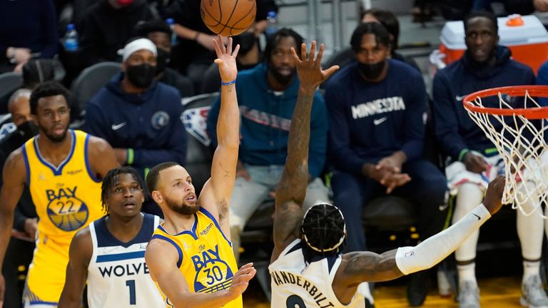Golden State Warriors guard Stephen Curry shoots between Minnesota Timberwolves forward Anthony Edwards and forward Jarred Vanderbilt during the second half of an NBA basketball game in San Francisco, Thursday, Jan. 27, 2022.
