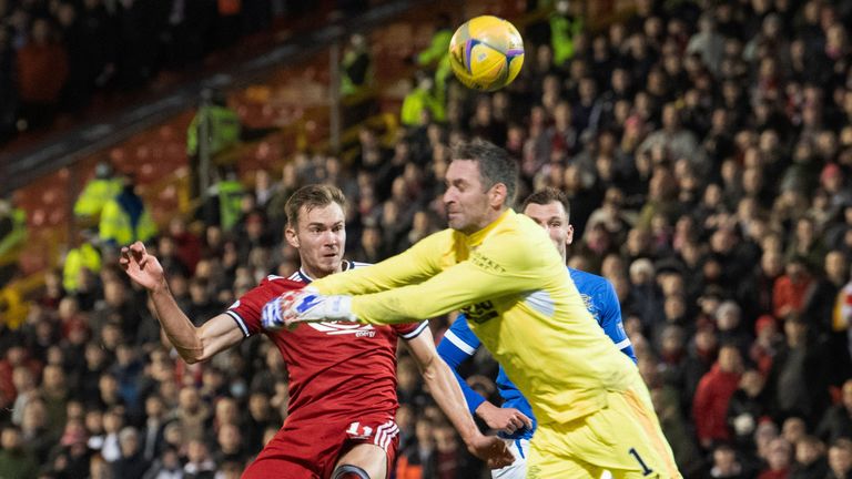 ABERDEEN, SCOTLAND - JANAURY 18: Aberdeen's Ryan Hedges (left) nicks the ball past Rangers' Allan McGregor who collides with him but nothing is given during a Cinch Premiership match between Aberdeen and Rangers at Pittodrie, on January 18, 2022, in Aberdeen, Scotland. (Photo by Ross Parker / SNS Group)