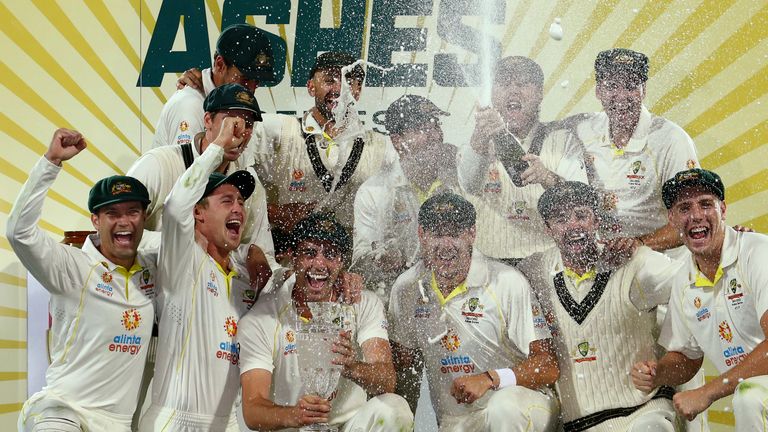 AP - Australia's players spray champagne as they pose with the trophy after winning the Ashes cricket match and the series against England in Hobart, Australia, Sunday, Jan. 16, 2022. (AP Photo/Tertius Pickard)..