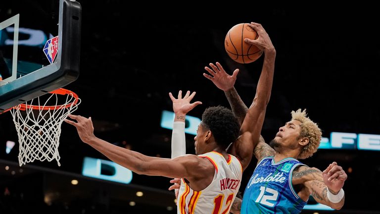Atlanta Hawks forward De&#39;Andre Hunter, left, drives to the basket as Charlotte Hornets guard Kelly Oubre Jr., right, attempts to block the shot