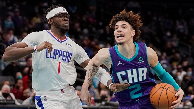 Charlotte Hornets guard LaMelo Ball drives around Los Angeles Clippers guard Reggie Jackson during the second half of an NBA basketball game Sunday, Jan. 30, 2022, in Charlotte, N.C. 