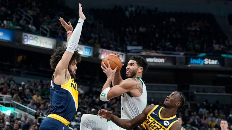 Boston Celtics forward Jayson Tatum puts up a shot against Indiana Pacers guard Duane Washington Jr.  and guard Caris LeVert 