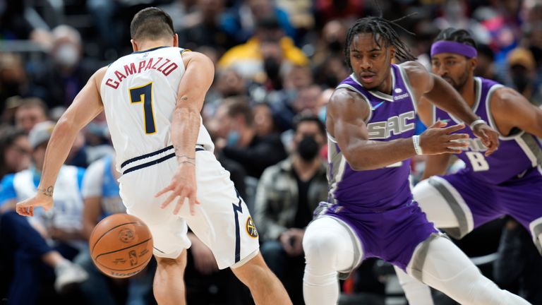 Denver Nuggets guard Facundo Campazzo tries to retrieve a loose ball as Sacramento Kings guard Davion Mitchell defends 