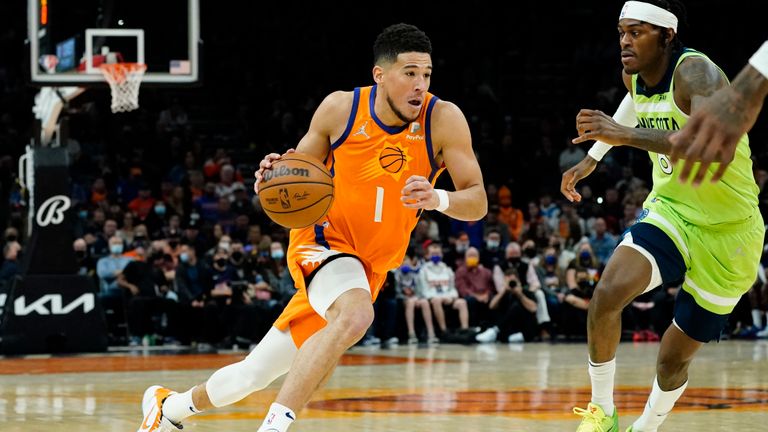 Phoenix Suns guard Devin Booker (1) drives against the Minnesota Timberwolves during the second half of an NBA basketball game, Friday, Jan. 28, 2022, in Phoenix. The Suns defeated the Timberwolves 134-124. (AP Photo/Matt York)