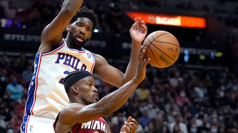 Miami Heat forward Jimmy Butler passes the ball as Philadelphia 76ers center Joel Embiid defends during the second half of an NBA basketball game, Saturday, Jan. 15, 2022, in Miami.