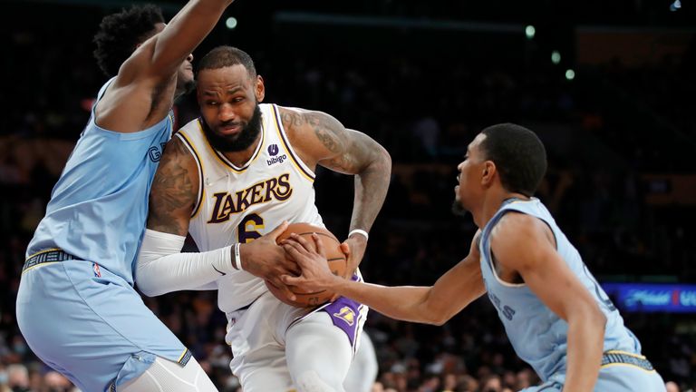 Los Angeles Lakers forward LeBron James, center, collides with Memphis Grizzlies forward Jaren Jackson Jr., left, as guard De&#39;Anthony Melton, right, reaches for the ball during the second half of an NBA basketball game, Sunday, Jan. 9, 2022, in Los Angeles. (AP Photo/Alex Gallardo)


