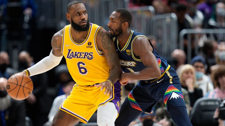 Los Angeles Lakers forward LeBron James looks to pass the ball as Denver Nuggets guard Davon Reed defends in the second half of an NBA basketball game Saturday Jan. 15, 2022, in Denver. The Nuggets won 133-96. 