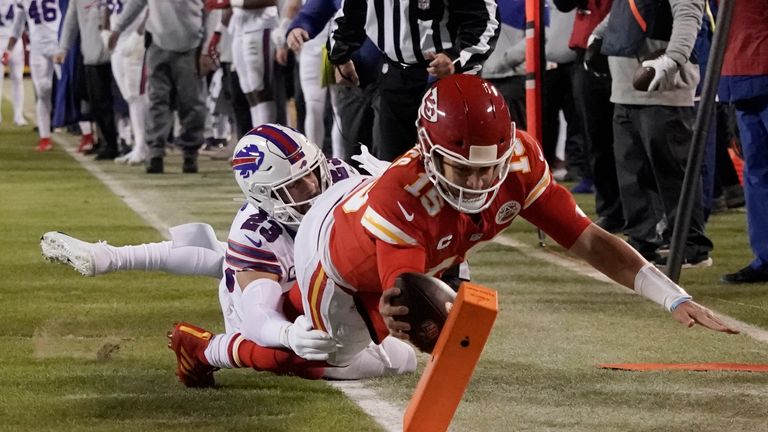 Kansas City Chiefs quarterback Patrick Mahomes (15) scores on an 8-yard touchdown run ahead of Buffalo Bills safety Micah Hyde (23) during the first half of an NFL divisional round playoff football game, Sunday, Jan. 23, 2022, in Kansas City, Mo.