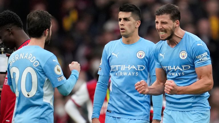 Man City players celebrate after winning at Arsenal