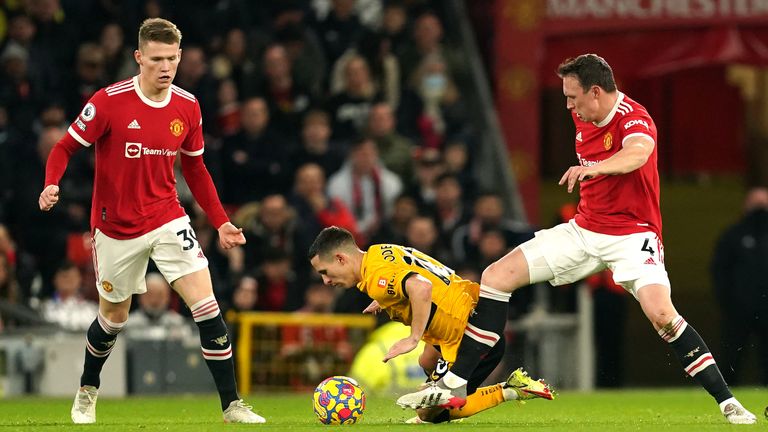 Phil Jones (derecha) del Manchester United desafía al Wolverhampton Wanderers  Daniel Podence (centro)